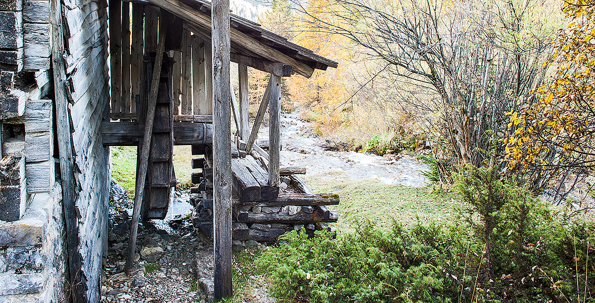 Das Rad einer hölzernen Mühle an einem Bach in Alta Badia