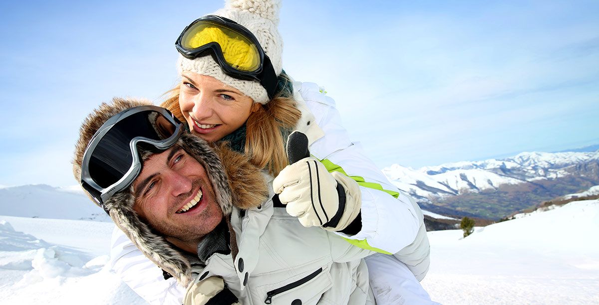 Man and woman are having fun in the snow dressed in ski clothes