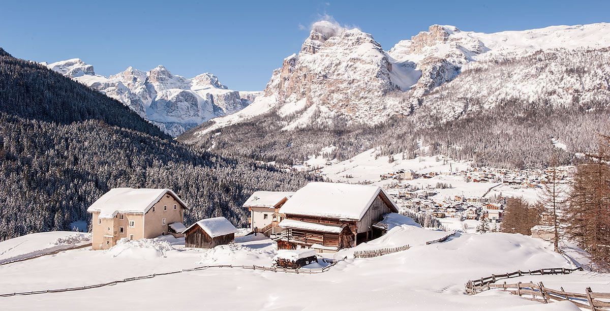 Houses surrounded by snow and high mountains in Alta Badia